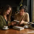 An author and editor comparing three different book formats at a rainy Seattle coffee shop window table