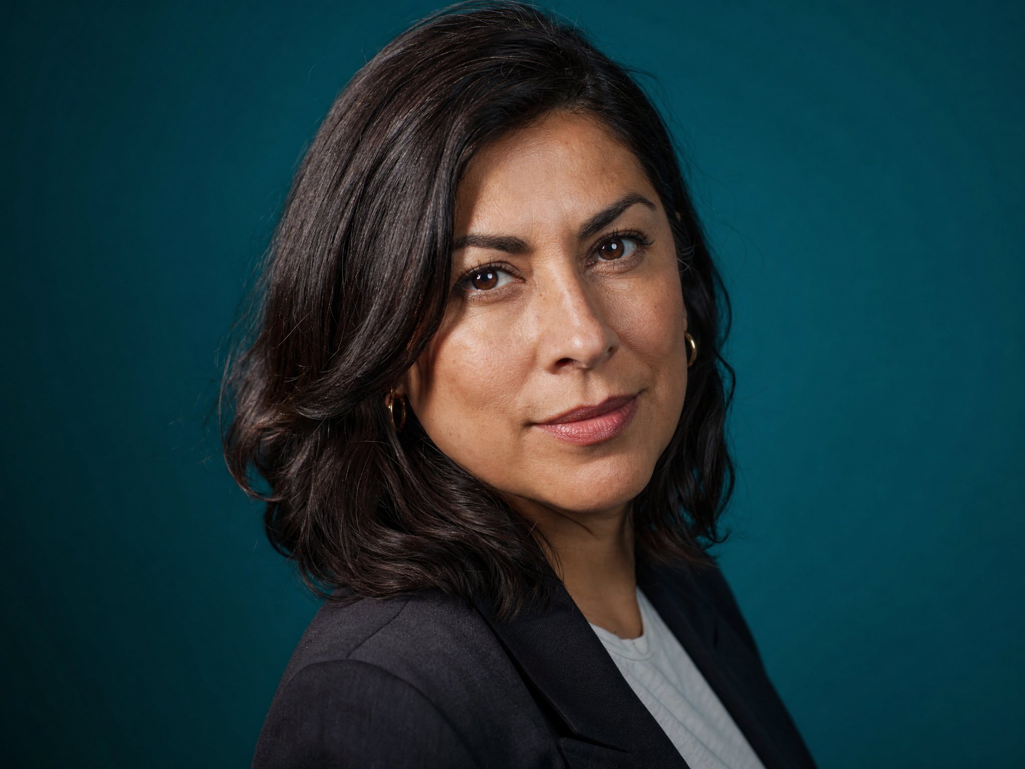 Featured author, a brand and product strategist, against a teal studio backdrop